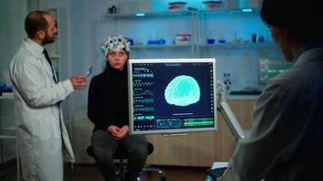 Science doctor looking at computer with medical brain scan film showing on monitor in neurology clinic. Woman sitting in neurological scientific laboratory treating nervous system dysfunctions video