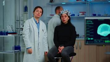 Researcher and patient with eeg headset looking at virtual display with touchscreen, virtual reality using medical inovation in neurological research lab. Scientists working with healthcare simulator video