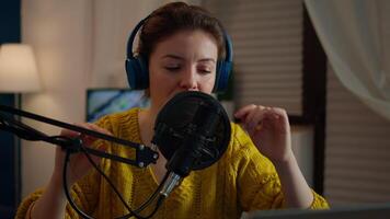 Creative blogger wearing headphones checking sound before talking with fans during live on social media, podcasting. On-air online production internet broadcast show host streaming live content video