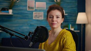 Portrait of vlogger looking at camera and smiling before starting live vlog, recording podcast. On-air online production internet broadcast show host streaming blog content from studio video
