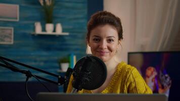 Social media influencer smiling at camera sitting in home studio ready for streaming new podcast. On-air online production internet broadcast show host streaming live content record digital blog video