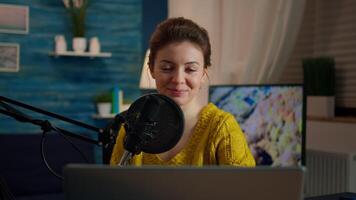 Woman blogger sitting in home studio looking at camera preapring for live recording podcast show. On-air online production internet broadcast host streaming web content record digital blog video