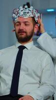 Vertical . Neurologist doctor analysing brain of man and nervous system using brainwave scanning headset. Researcher using high tech developing neurological innovation monitoring side effects on monitor screen video