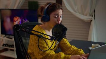 Blogger speaking at microphone with followers livestreaming typing on laptop. Online show On-air production internet broadcast host streaming live content, recording digital social media communication video