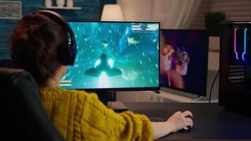 Gamer playing shooter games with other players late at night during gaming championship. Pro esport team player streamer during e-game tournament on powerful RGB computer, using streaming technology video