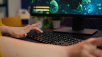 Close up hands shot of gamer pushing the keyboard buttons while playing online shooter game. Virtual championship in cyberspace, esports player performing on pc during gaming tournament video