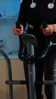 Vertical . Team of doctor researchers monitoring endurance of woman performance sports. Athlete wearing mask running cross trainer while scientist talks with her measuring vo2, health status, physical enducance video