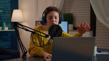 Blogger opening laptop starting to talk with followers recording new podcast at home studio. On-air online production internet broadcast show host streaming live content, recording digital vlog video