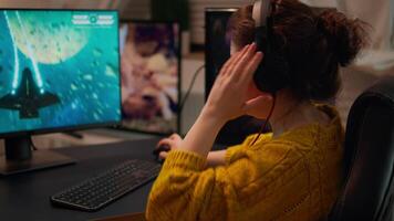 Professional esport woman gamer using mic of headset talking playing shooter game with team on streaming services. Virtual shooter game in cyberspace, esports player performing on pc gaming tournament video