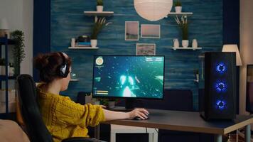 Professional gamer playing first-person shooter online game on powerful personal computer with colorful neon led lights. Cyber performing on pc in stylish room during gaming tournament video
