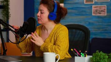 Influencer host talking and gesturing while recording vlog in home studio podcast. On-air online production internet broadcast show host streaming live content for social media video