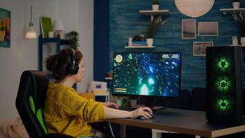 Professional gamer with headset starting to play online game in living room. Pro esport team player streamer playing gaming tournament on powerful RGB computer, using modern streaming technology video