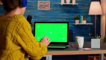 Blogger typing at laptop with green screen display recording new podcast series for audience. Broadcast show host streaming live content for social media using mochup, chroma key, izolated desktop video