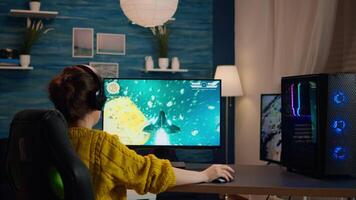 Professional eSports gamer skilfully plays 3D shooter mock-up game with super action and special effects on computer using headset. Cyber performing on powerful pc in stylish room video