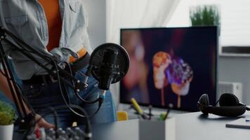 Beautiful podcaster sitting at studio desk with modern audio equipment. Live internet talk show host sitting in radio office with professional microphone and laptop while being on air. video