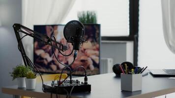 Empty broadcasting studio with professional audio equipment and no host. Radio podcast desk inside office workspace with laptop and microphone and nobody in it. Studio shoot video
