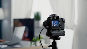 Camera filming digital content creator speaking to public. Famous social media star recording vlog for sharing platforms while sitting at studio desk in living room. Close up video