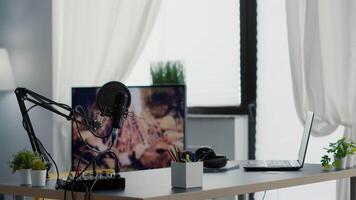 Empty streaming studio booth with modern professional audio equipment. Podcast broadcast desk having recording devices and gadgets inside office workspace with nobody in it. Studio shot video