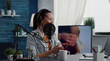 Happy internet live radio morning show host talking to audience on microphone. Joyful social media content creator hosting online broadcast while speaking to public in modern living room studio. video