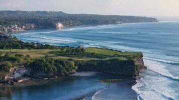 Scenic coastline with ocean and perfect swell waves. Drone view of Bali landscape video