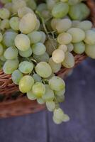 Bunch of white grapes in a basket on a wooden background. photo