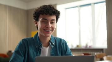 Caucasian man male student guy boy schoolboy pupil with toothy dental braces in class lesson school university studying learning education study learn using laptop computer e-learning knowledge online video
