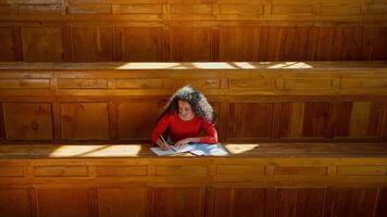 Hispanic woman concentrated Latina girl student female lady study at table writing task homework studying learning write learn course copybook in empty classroom college university academy auditorium video