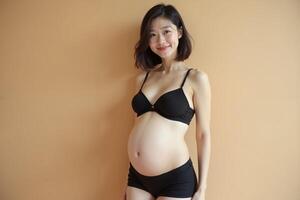 photo of pregnant woman standing pose with beige background,