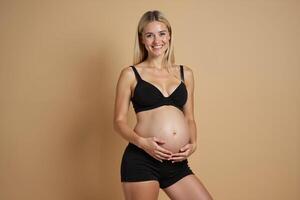 photo of pregnant woman standing pose with beige background,