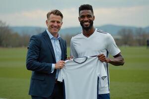 photo of coach and player holding shirt in the stadium field at signing contract event,