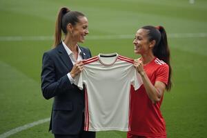 photo of coach and player holding shirt in the stadium field at signing contract event,