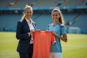 photo of coach and player holding shirt in the stadium field at signing contract event,