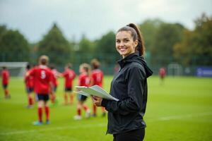 photo of coach instructor trainer teaching teenage player at soccer field,