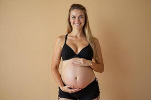 photo of pregnant woman standing pose with beige background,