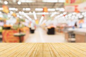 Empty wood table top with supermarket blurred background for product display photo