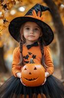 A young girl with black pigtails, an orange shirt, a witch hat, and a pumpkin photo