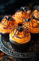 Halloween themed cupcakes with spider decorations are creatively arranged on a festive plate for display photo