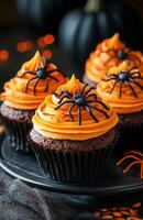 Halloween themed cupcakes with spider decorations are creatively arranged on a festive plate for display photo