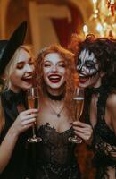 Friends in costume clinking champagne glasses at a Halloween party, celebrating joyfully together photo