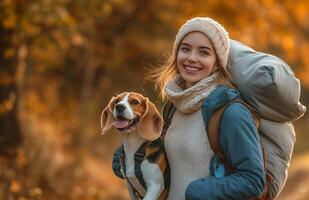 A joyful woman strolls in an autumn park with her beagle and a sleeping bag photo