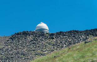observatory on top of a mountain against a blue sky photo