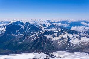 top view of the high mountains above the clouds from the slope of Mount Elbrus photo
