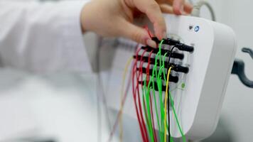 Close-up of a doctor handling EEG sensors, highlighting precision and care in advanced diagnostic procedures. Ideal for showcasing modern medical technology and professional expertise. video
