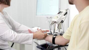 The patient undergoes an electromyography EMG test to assess nerve activity. Detects nerve and muscle dysfunctions. Perfect for showcasing advanced medical video