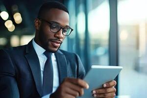 Close up of young businessman using digital tablet while sitting at his working place in office. Businessman using digital tablet photo
