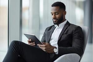 Close up of young businessman using digital tablet while sitting at his working place in office. Businessman using digital tablet photo