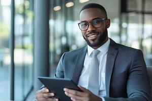 Close up of young businessman using digital tablet while sitting at his working place in office. Businessman using digital tablet photo