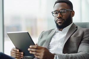 Close up of young businessman using digital tablet while sitting at his working place in office. Businessman using digital tablet photo