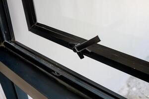 The handle of the new plastic door. black front door in a house under construction photo