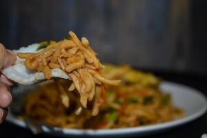 Fried noodles are one of the most popular foods in Southeast Asia, including Indonesia. Served with eggs and vegetables, on a plate photo